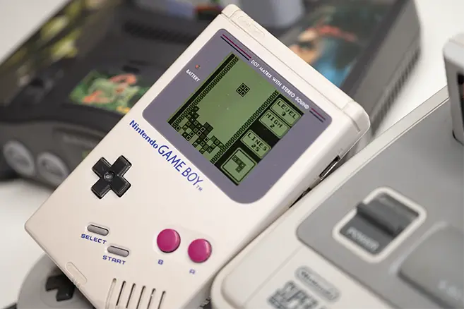 Game Boy mit laufendem Spiel als Symbol für mobile Videospiele der 90er Jahre